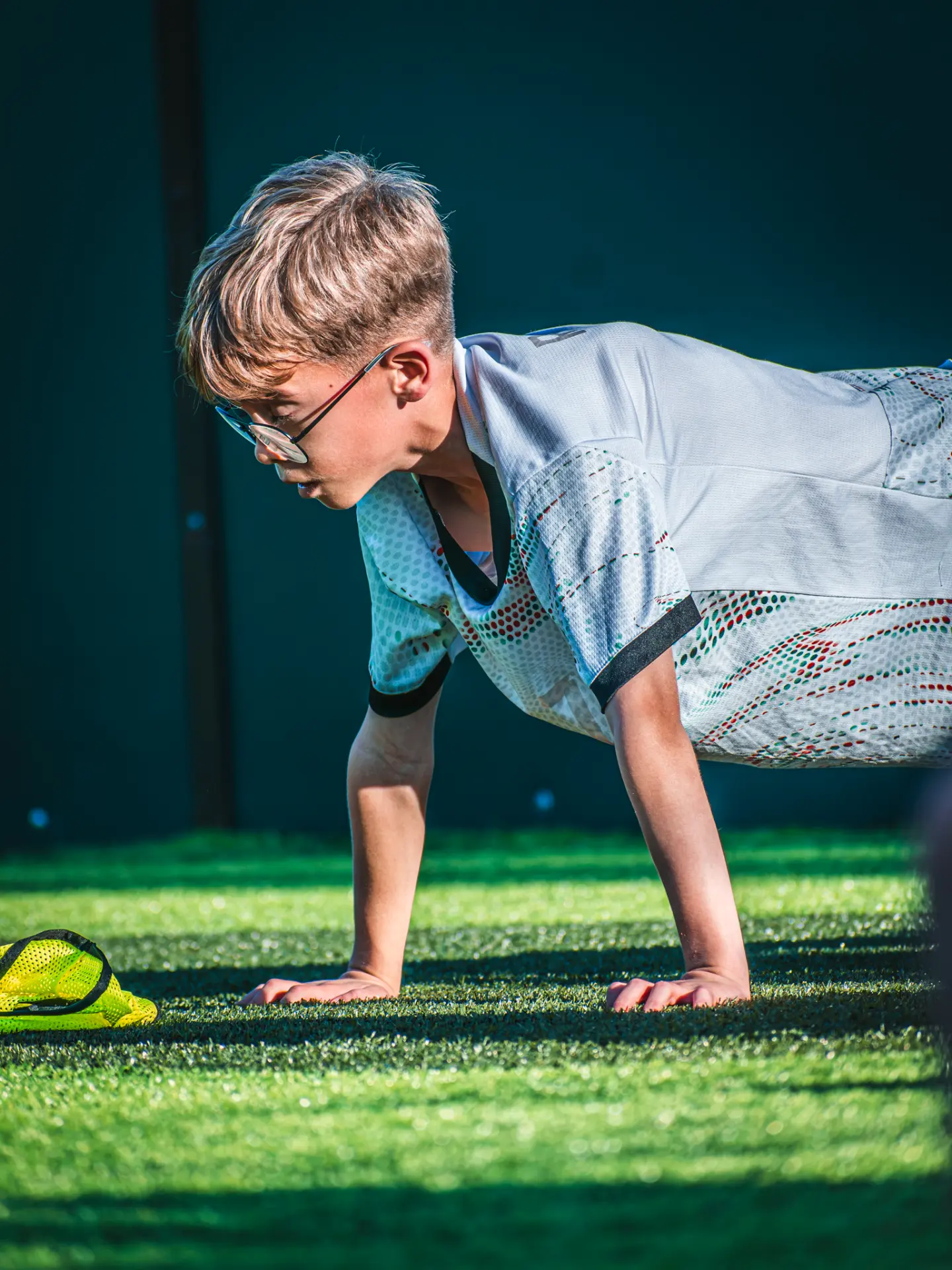 Young player doing press-ups on the pitch