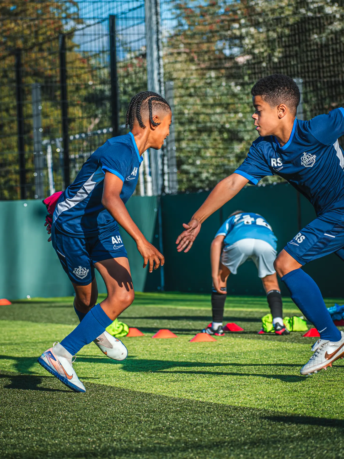 Two Aspire players high-fiving during a warm-up drill