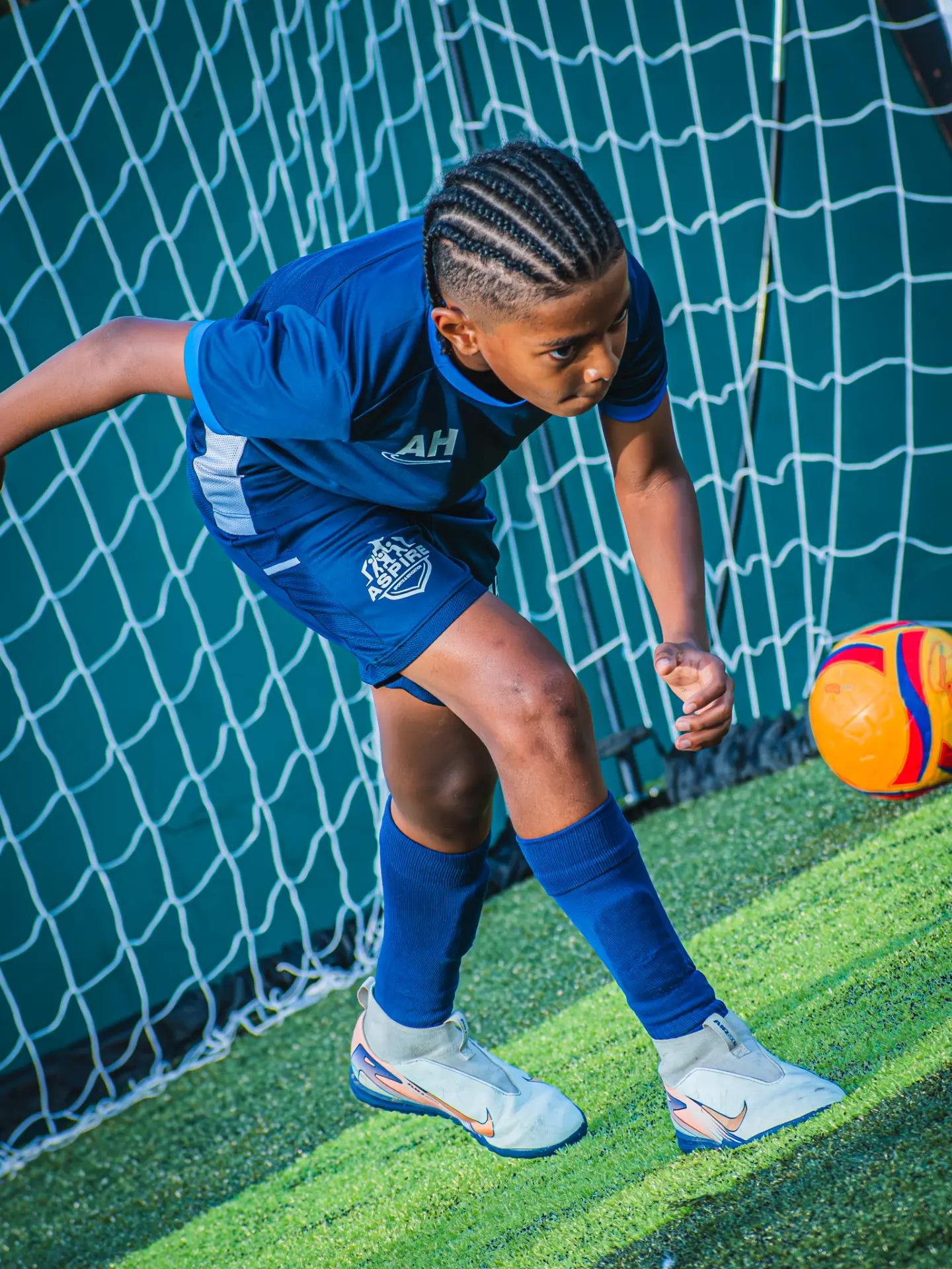 Young Aspire player turning towards the ball in front of goal