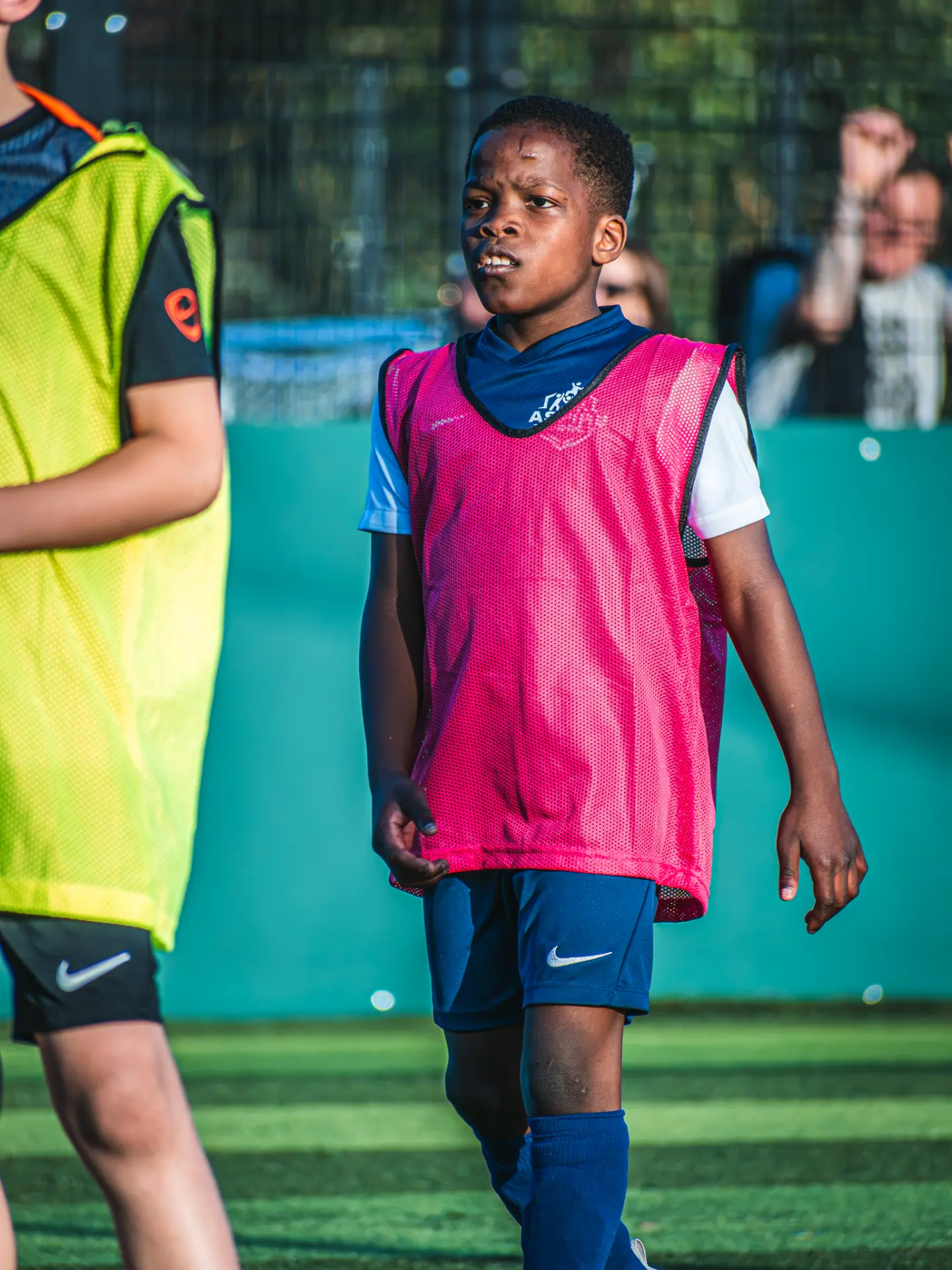 Young player in a pink bib focused during a session