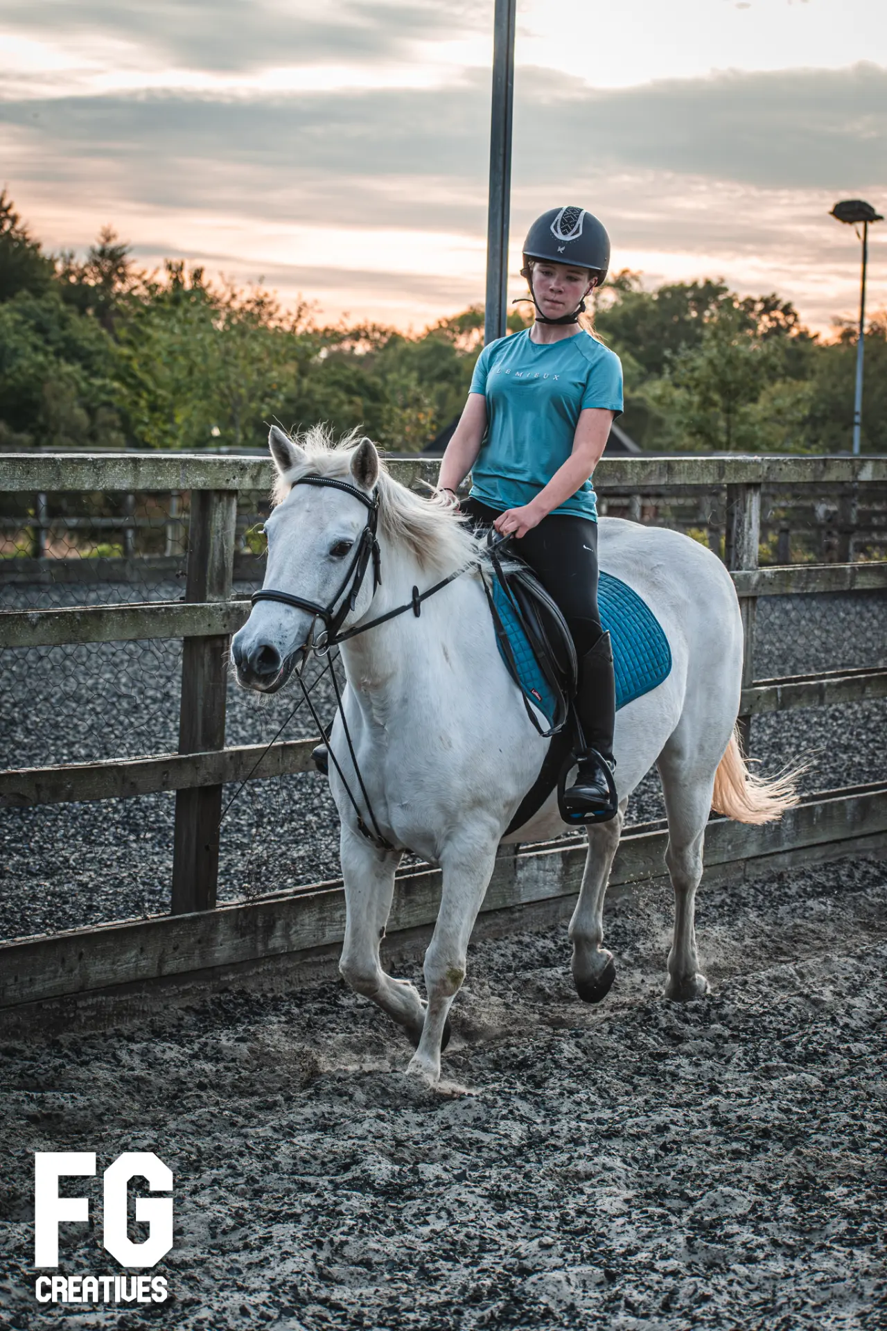 Rider and white horse photographed in warm evening light