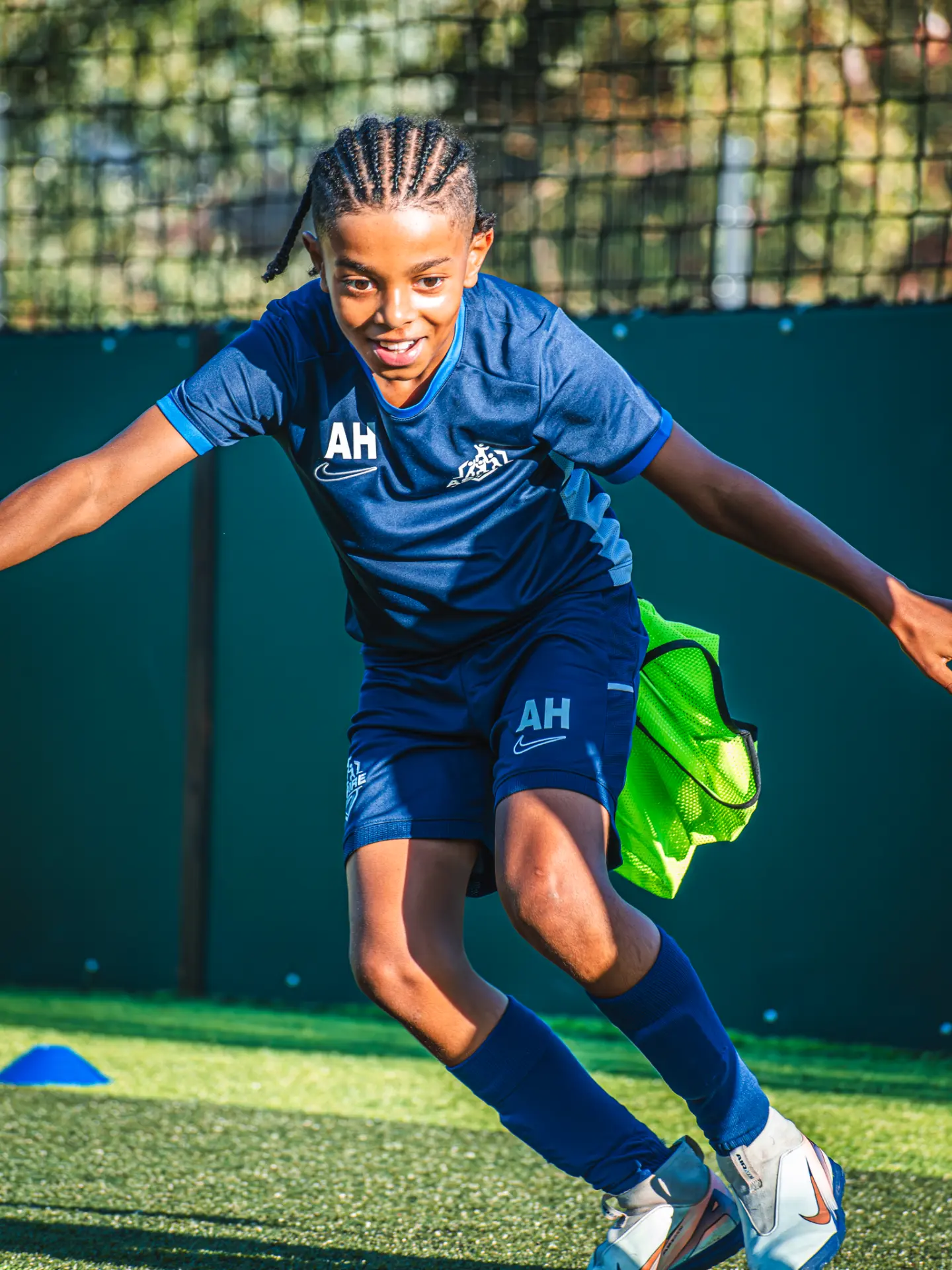Young Aspire player smiling as he sprints through a cone drill