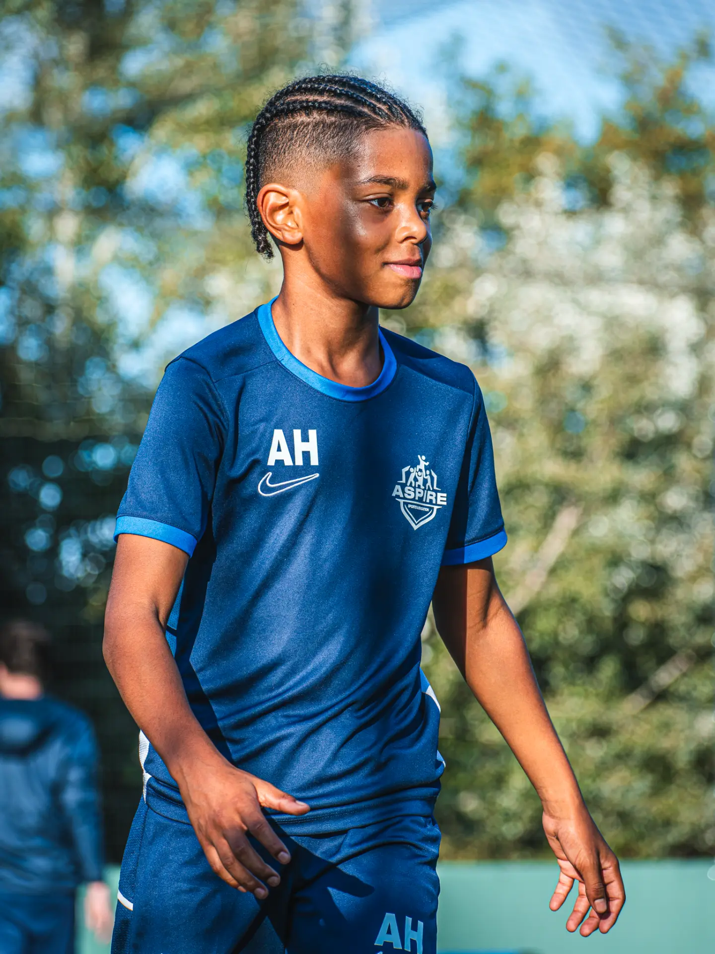 Aspire player in navy kit walking across the pitch