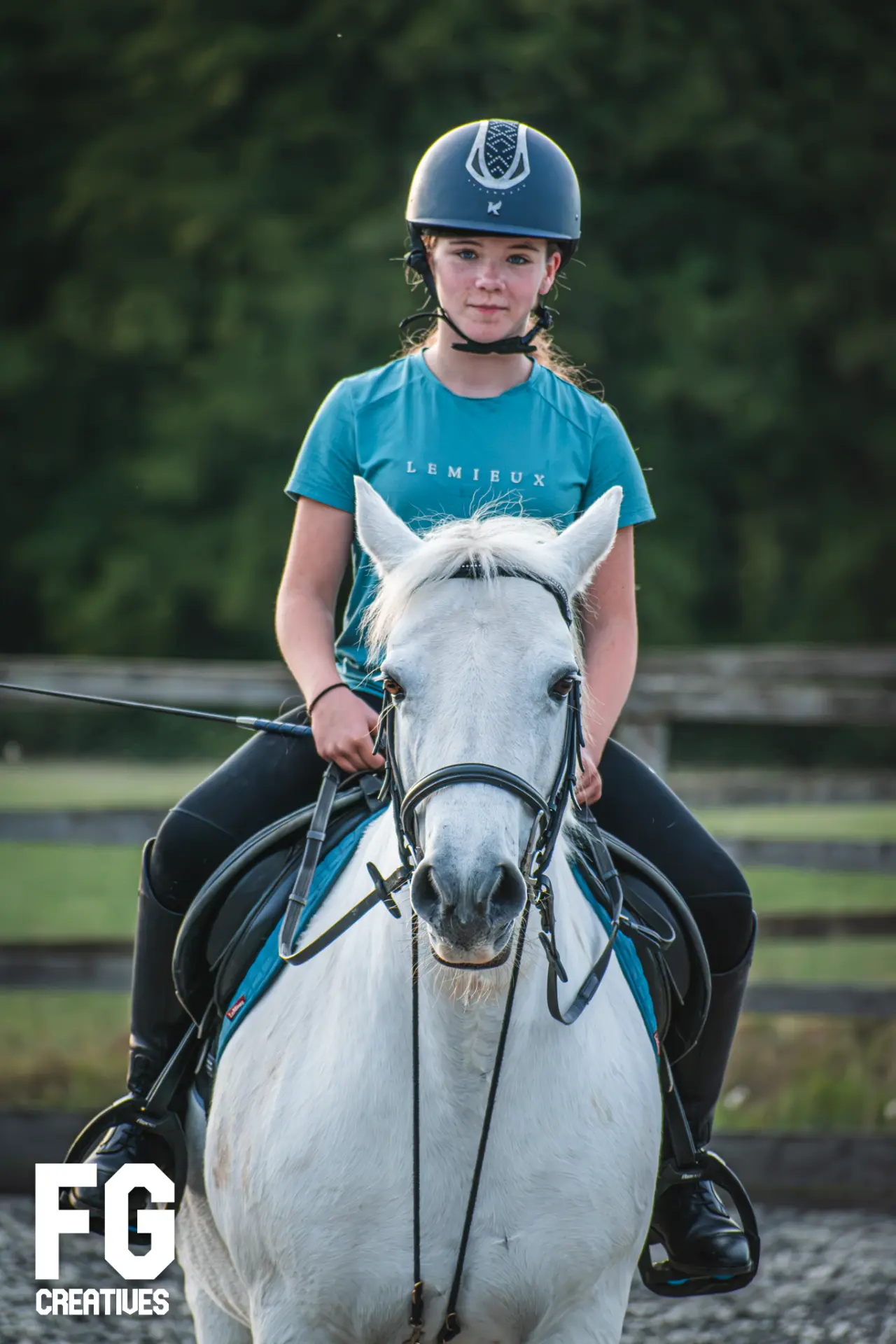 Front-facing portrait of an equestrian rider on a white horse