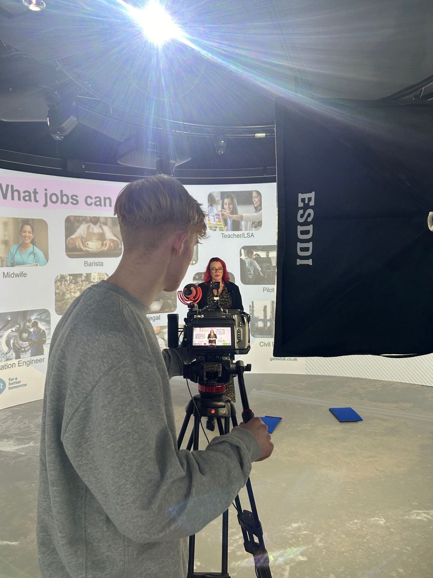 Flynn Gwilliams filming a presenter on a studio set with cinema camera and lighting