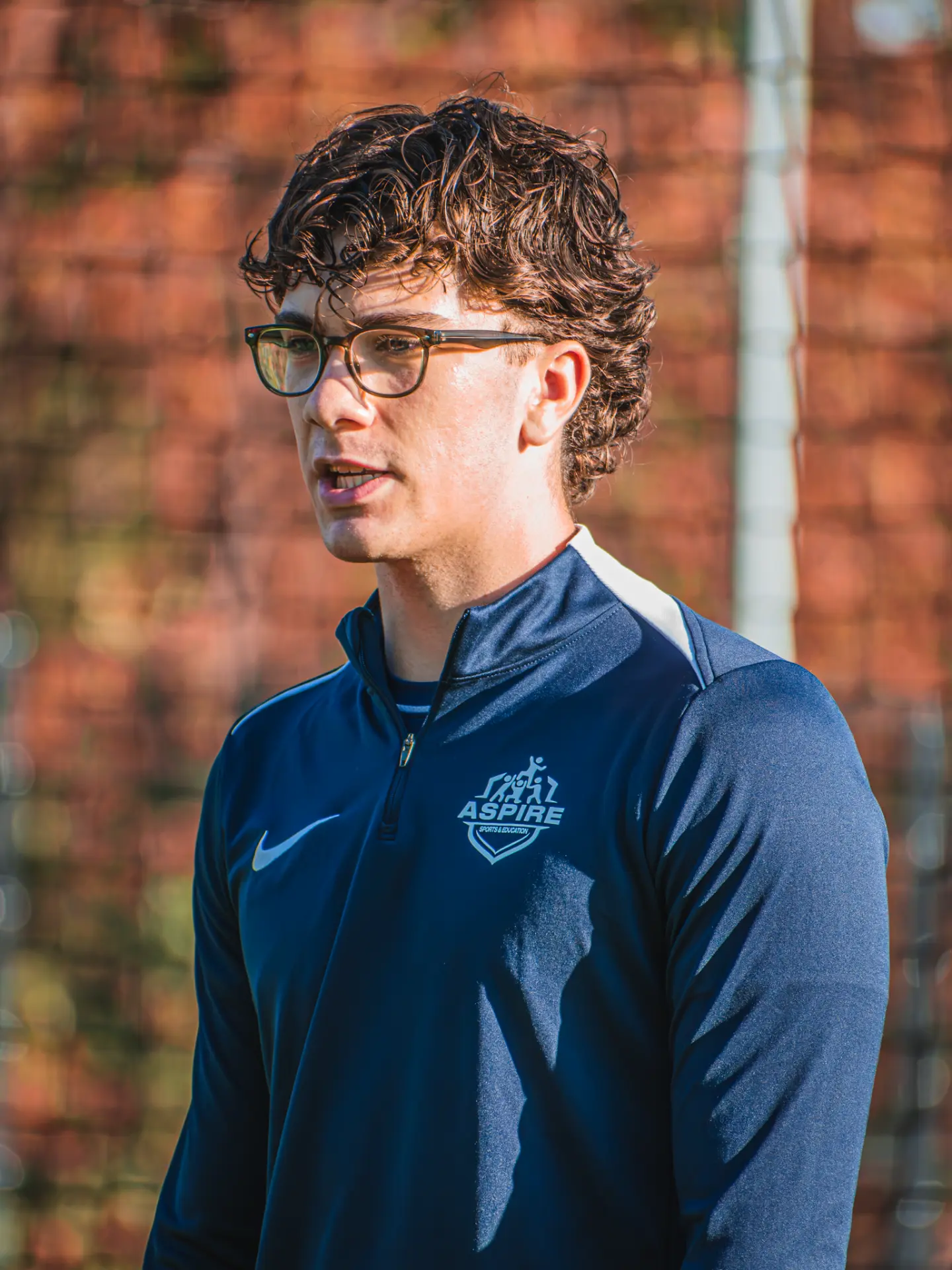 Aspire coach in glasses talking to players