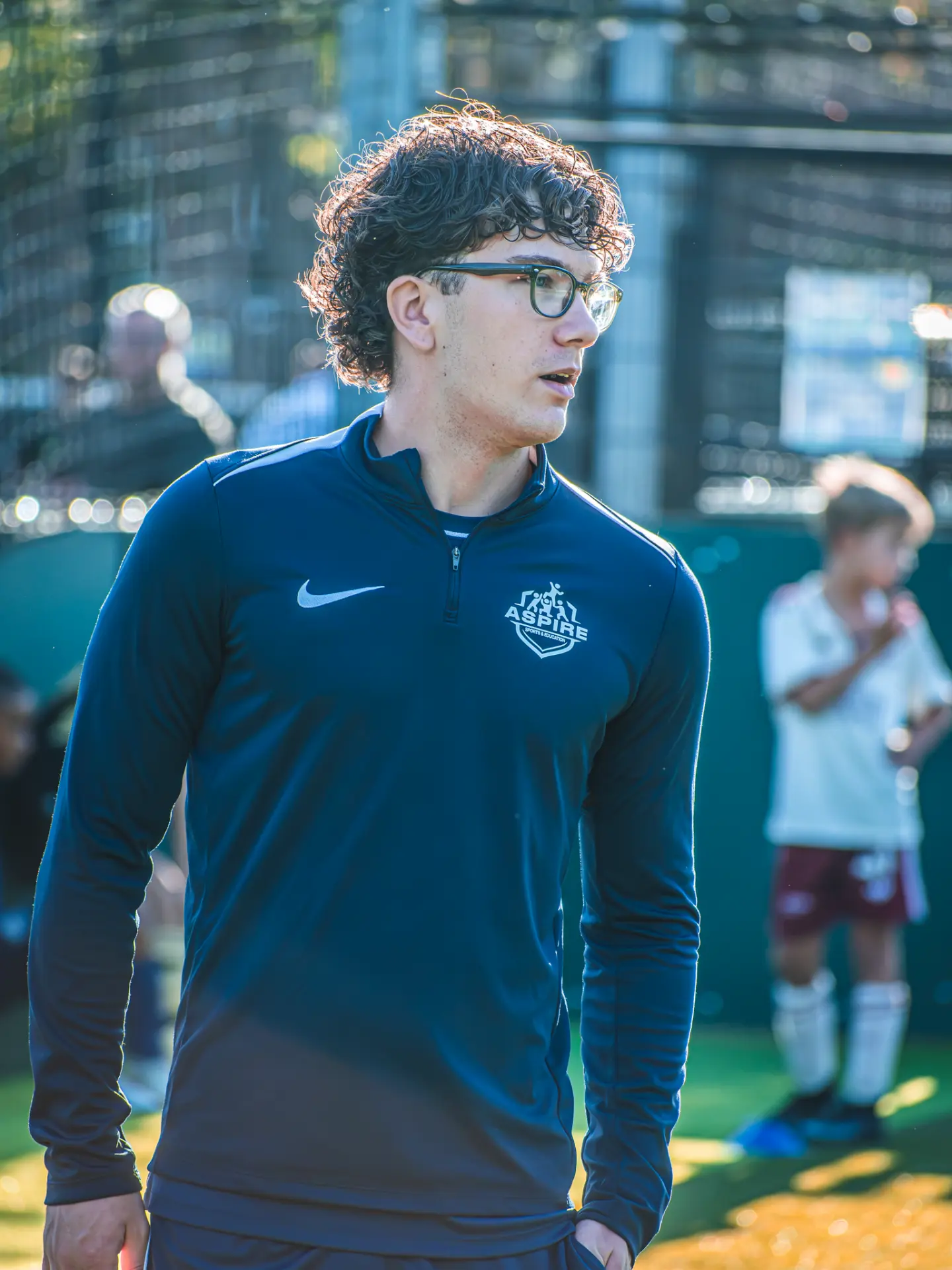 Aspire coach in glasses overseeing training